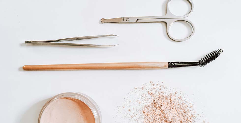 眉毛を整えるツール(ハサミ・毛抜き・スクリューブラシ・パウダー)が並べられている様子