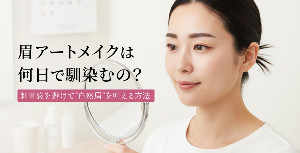 手鏡で自分の眉を確認している女性。ナチュラルメイクに似合う眉をしており、女性は優しく微笑んでいる。背景にはカレンダーやタオル、化粧品などが並んでいる「眉アートメイクは何日で馴染むの？刺青感を避けて“自然眉”を叶える方法」というタイトルの入った美容コラムのメインビジュアル。